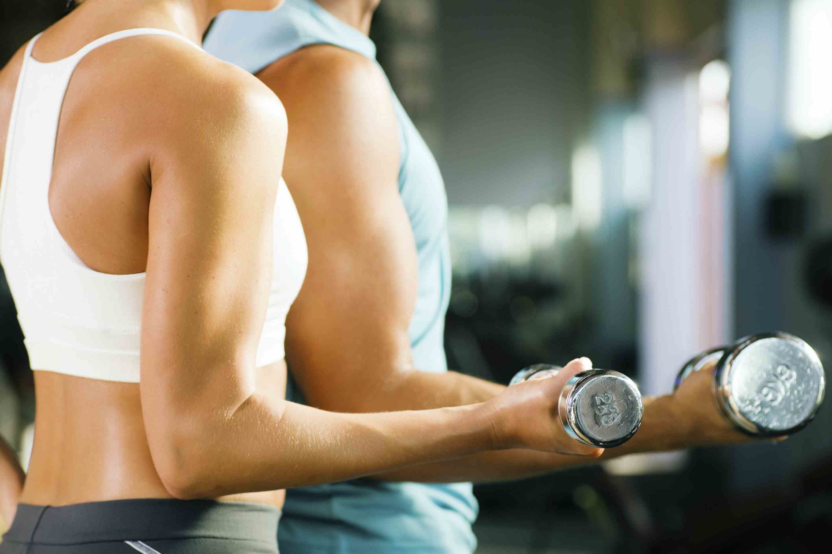 En person træner med håndvægte i et fitnesscenter.