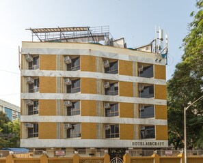 Un edificio de varios pisos con un letrero que dice "HOTEL AIRCRAFT" y un letrero que indica "NO ESTACIONAR".