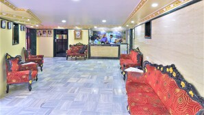 A lobby with patterned flooring, red sofas, and a reception desk. - Hotel Aircraft International (Mumbai)