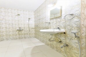 Un baño con lavabo, espejo y ducha.