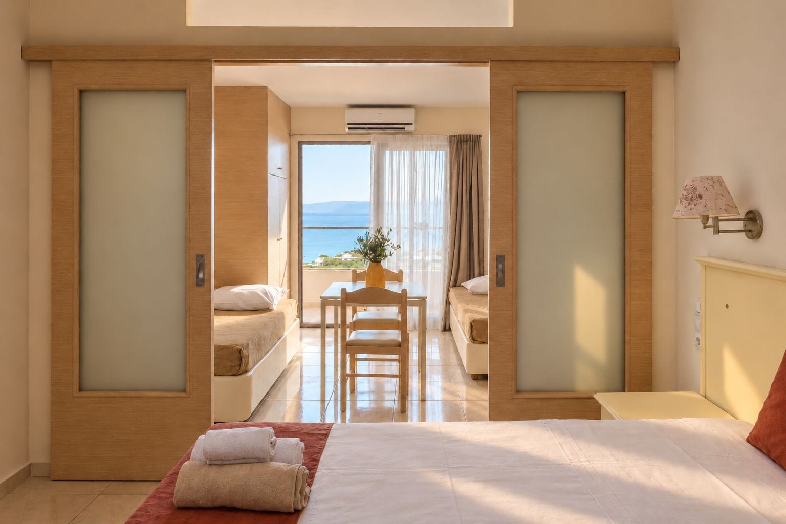Un cuarto de hotel con cama, escritorio y vista al mar.