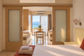 Un cuarto de hotel con cama, escritorio y vista al mar.