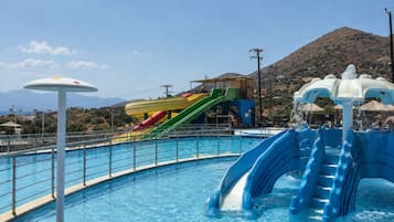 A swimming pool with a water slide and a lifeguard stand.