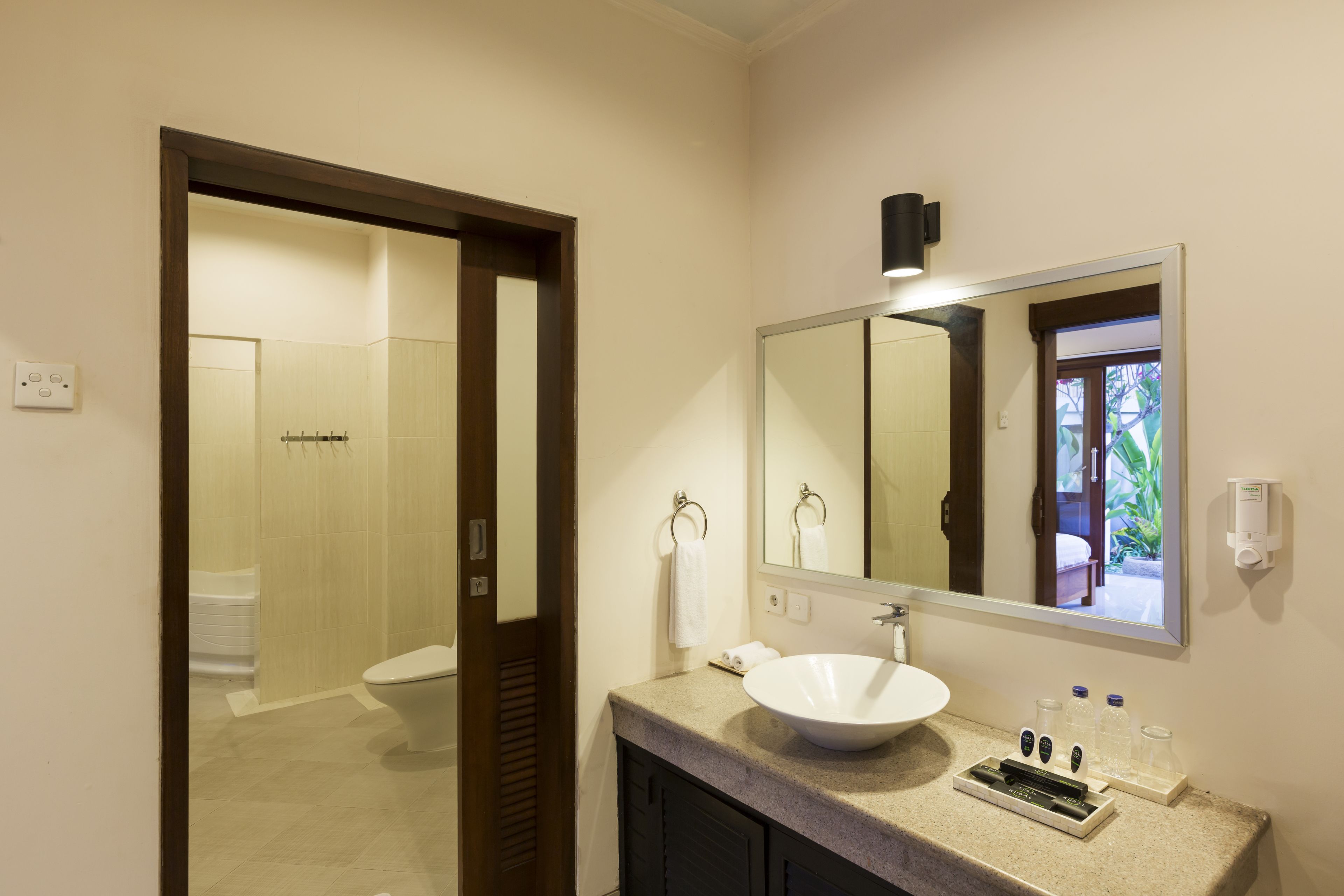 Ein Badezimmer mit Waschbecken, Spiegel und Toilette.