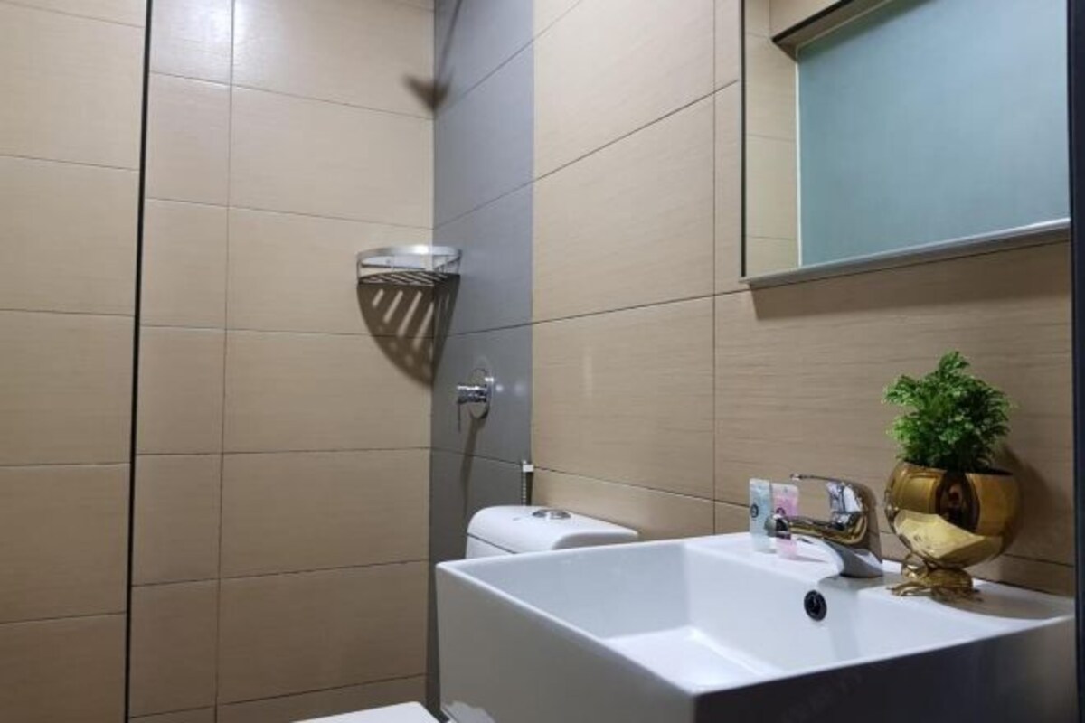 Een moderne badkamer met een groot wit wastafel, toilet en douche.