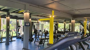 Un gimnasio con cintas de correr, máquinas de pesas y mancuernas.