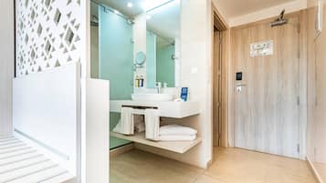 A modern bathroom with a white sink, mirror, and towel rack.