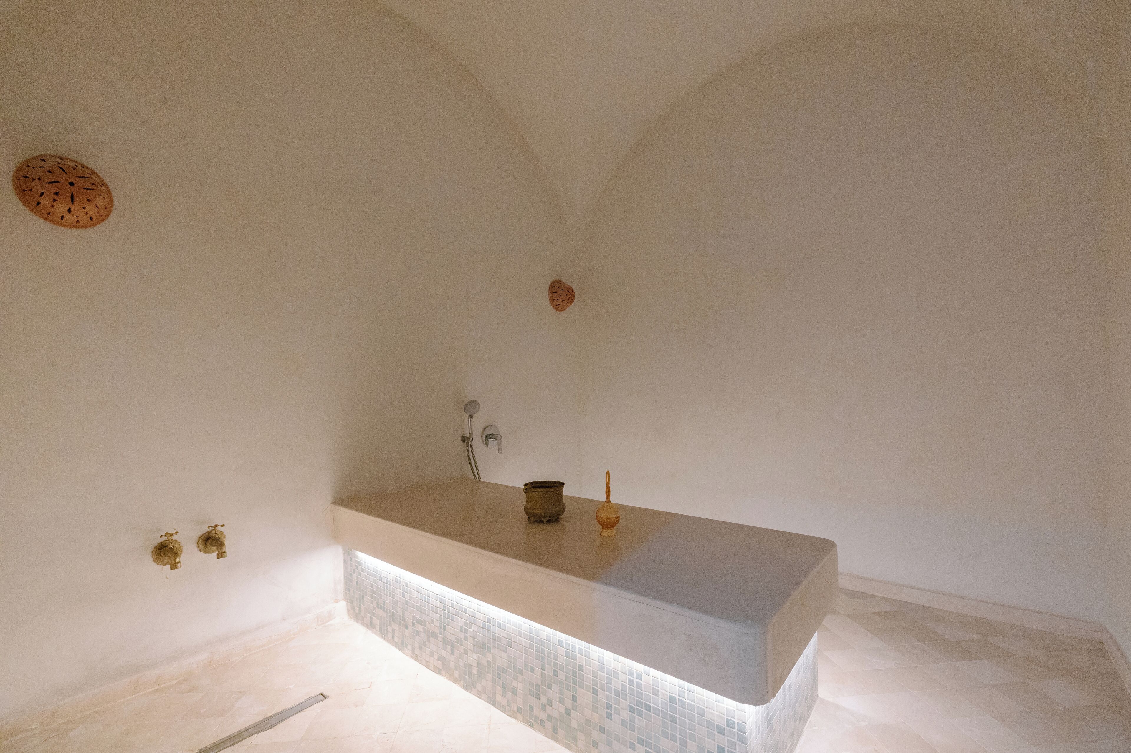 Ein schlichtes Badezimmer mit einer großen Badewanne, einer Dusche und zwei Wandarmaturen.