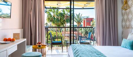 Une chambre d’hôtel avec un balcon, un lit, un bureau et une chaise.