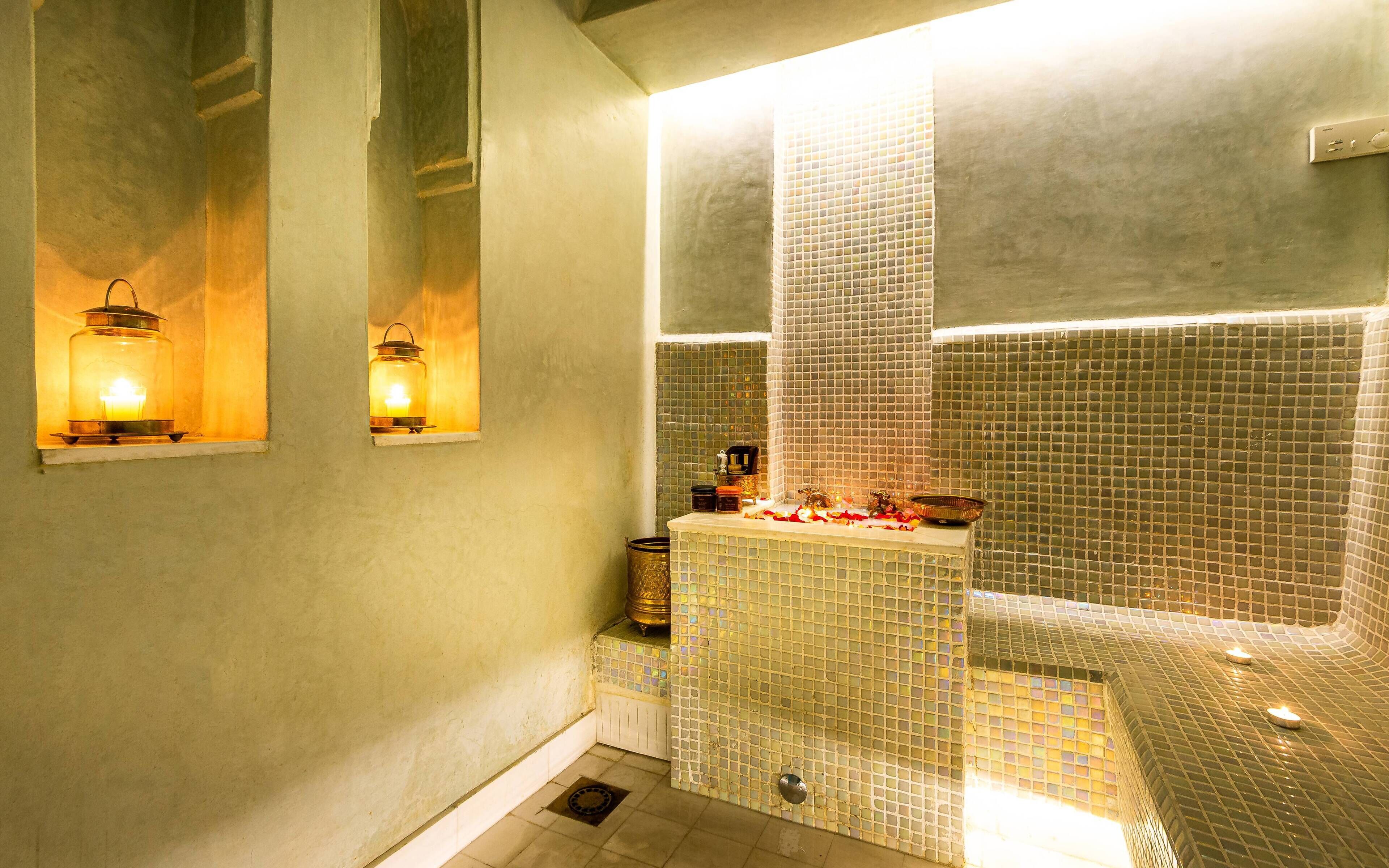 A bathroom with a bathtub, a sink, and two wall-mounted lights.