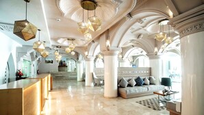A spacious lobby with a reception desk, a sofa, and a coffee table. - TUI BLUE Medina Gardens – Adults Only – All Inclusive (Marrakech)