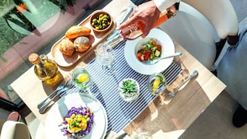 Una mesa preparada para una comida con diversos platos, una botella de aceite de oliva y un vaso de agua.