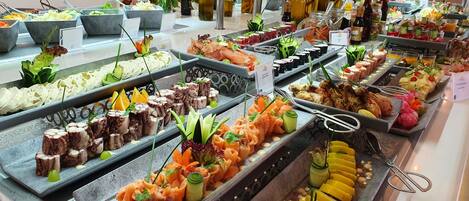 A buffet with various food items, including seafood, salads, and garnishes.