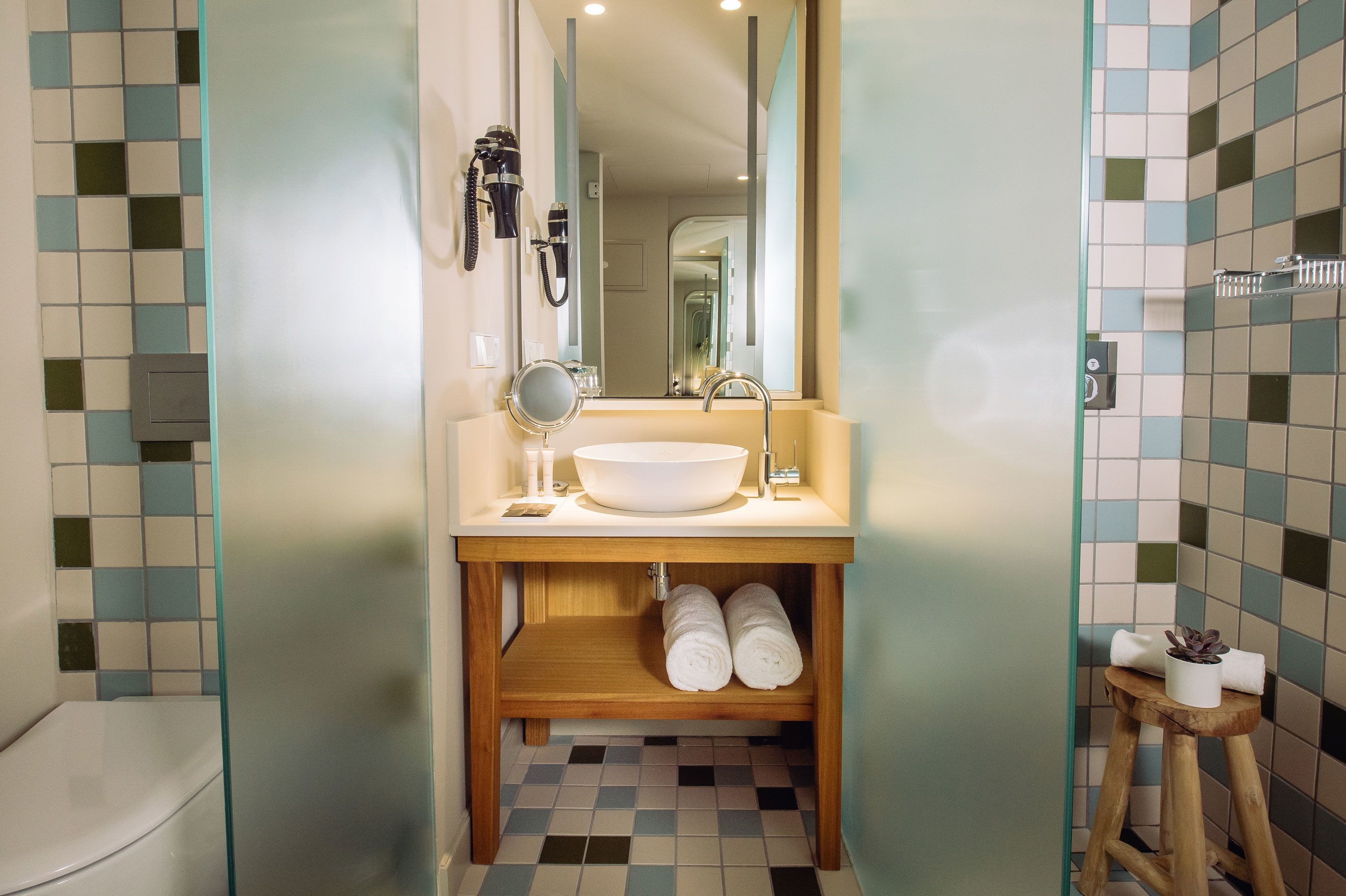 A bathroom with a white sink, a mirror, and a towel rack.