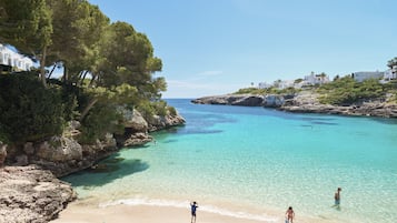 On the beach, white sand, sun-loungers, beach umbrellas