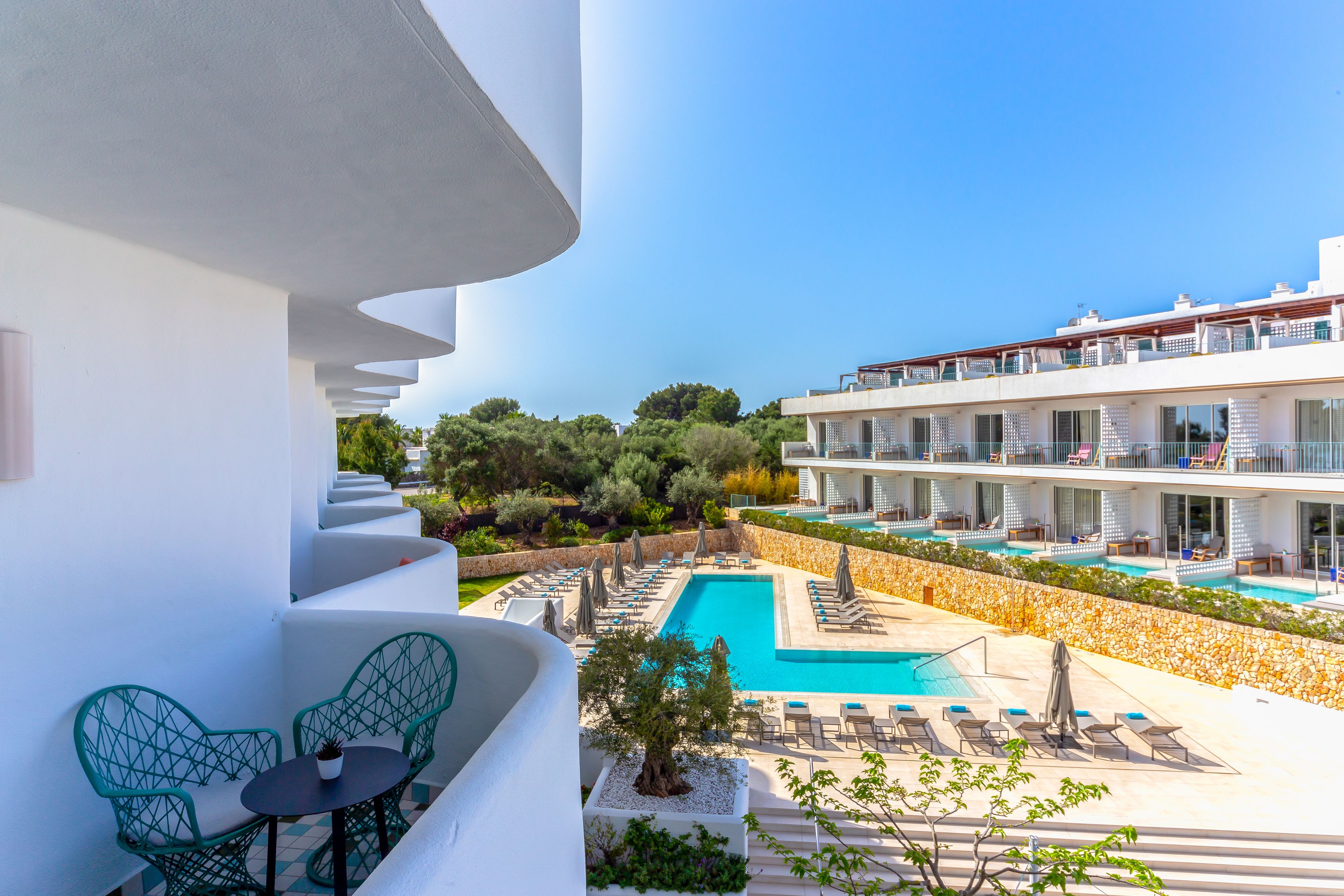 Un hotel con piscina, zona de estar al aire libre y vistas del paisaje circundante.