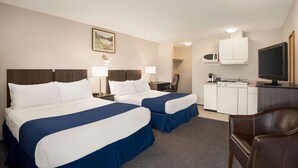 A hotel room with two beds, a desk, a television, a microwave, and a coffee maker.