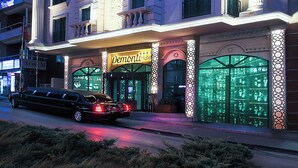 Un hotel con varios pisos, balcones y una entrada destacada con un cartel.