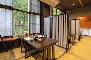 A room with a large window, a wooden table, and a partition with vertical slats. - Mount View Hakone (Hakone)