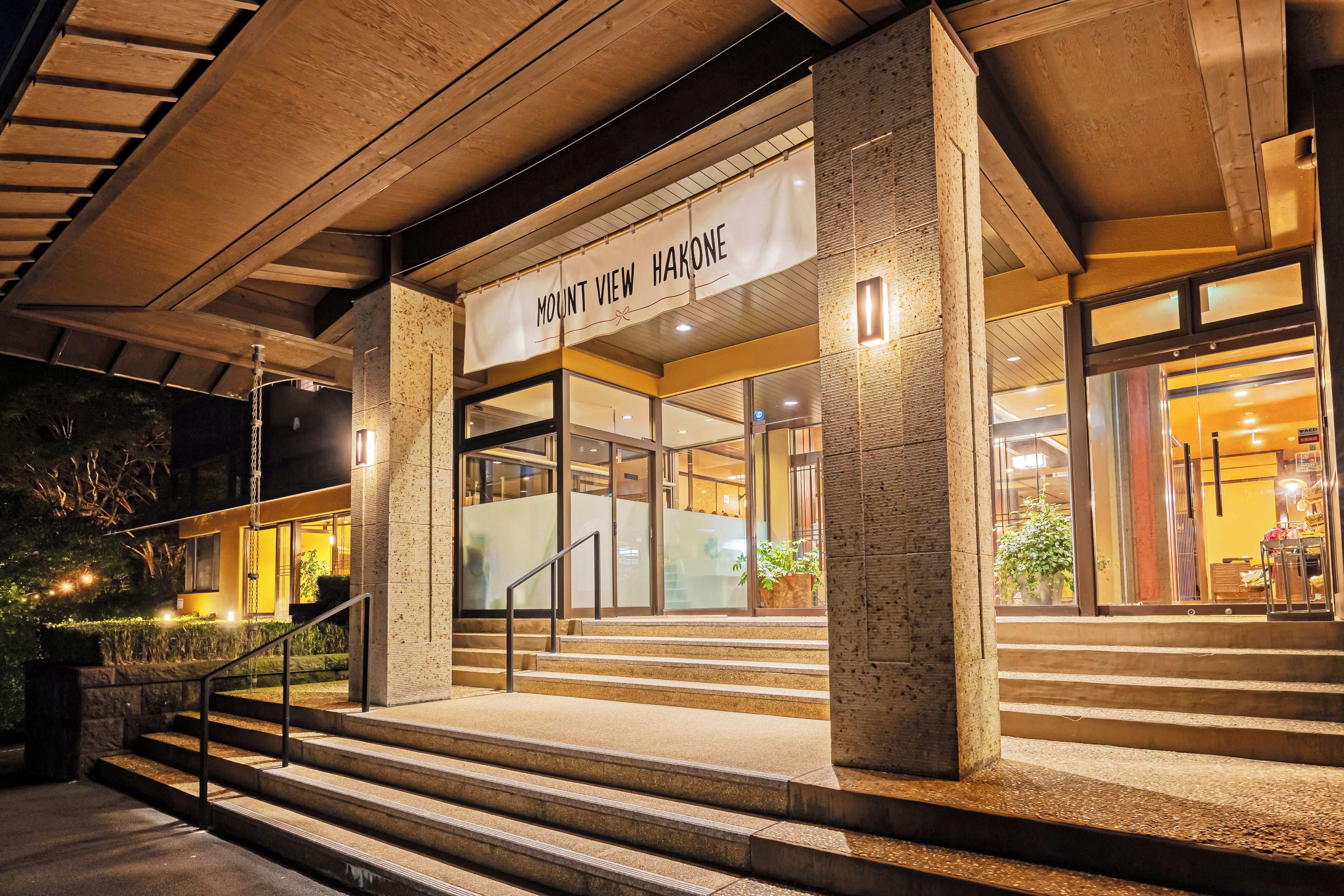 Un edificio con un letrero que dice 'Mount View Hakone' en la entrada, que presenta una escalera que sube hacia las puertas.