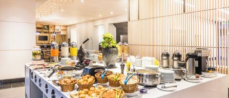 A buffet setup with various food items and kitchen appliances.