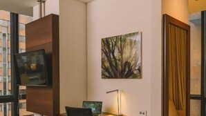 A hotel room with a desk, chair, TV, and a painting. - Holiday Inn Express & Suites Bogota DC (Bogotá)