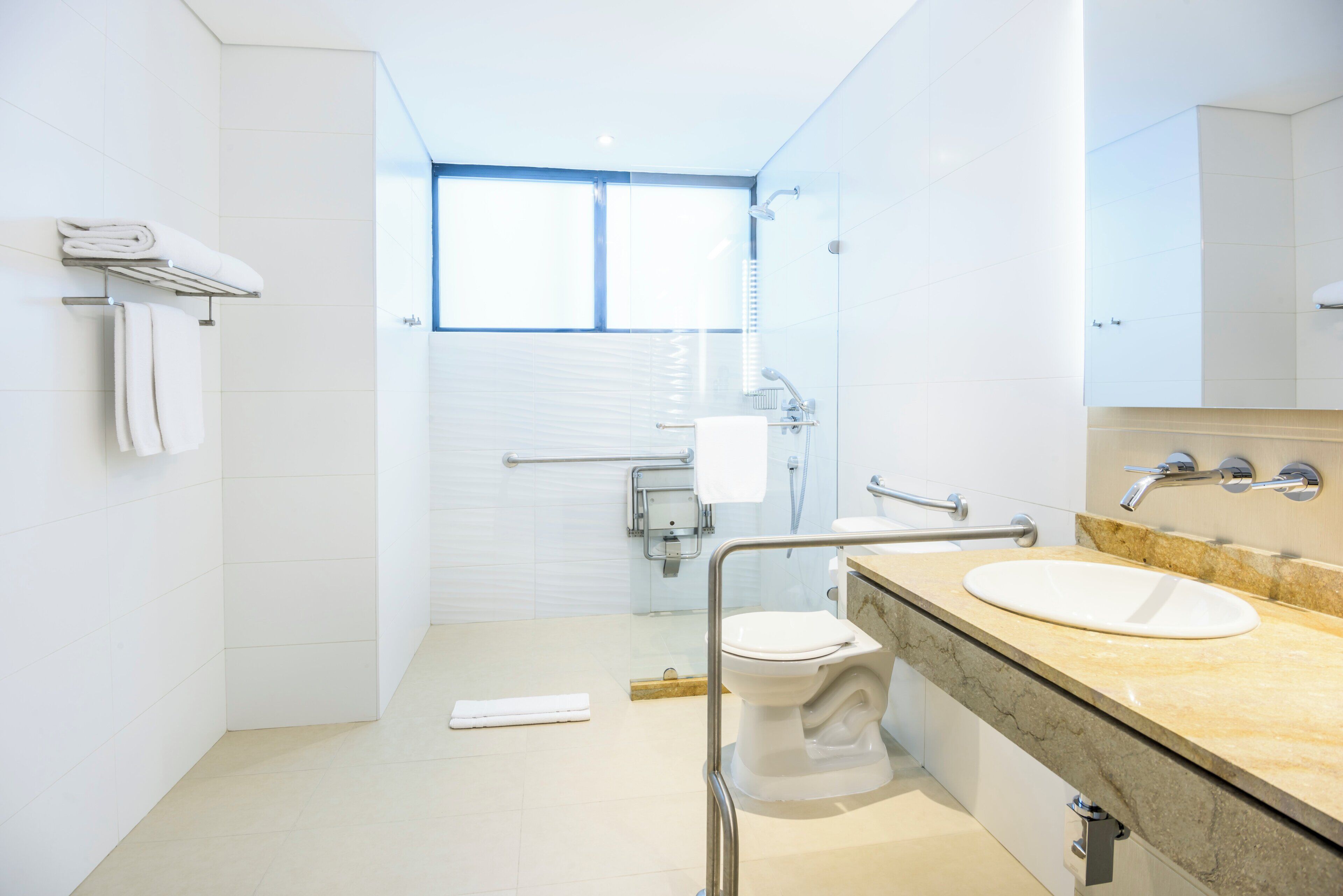 Een moderne badkamer met toilet, wastafel en douche.