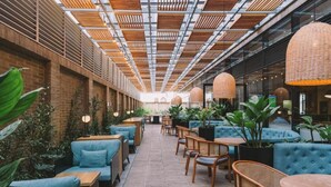 A modern indoor space with seating areas, wooden tables, and hanging lamps. - Holiday Inn Express & Suites Bogota DC (Bogotá)