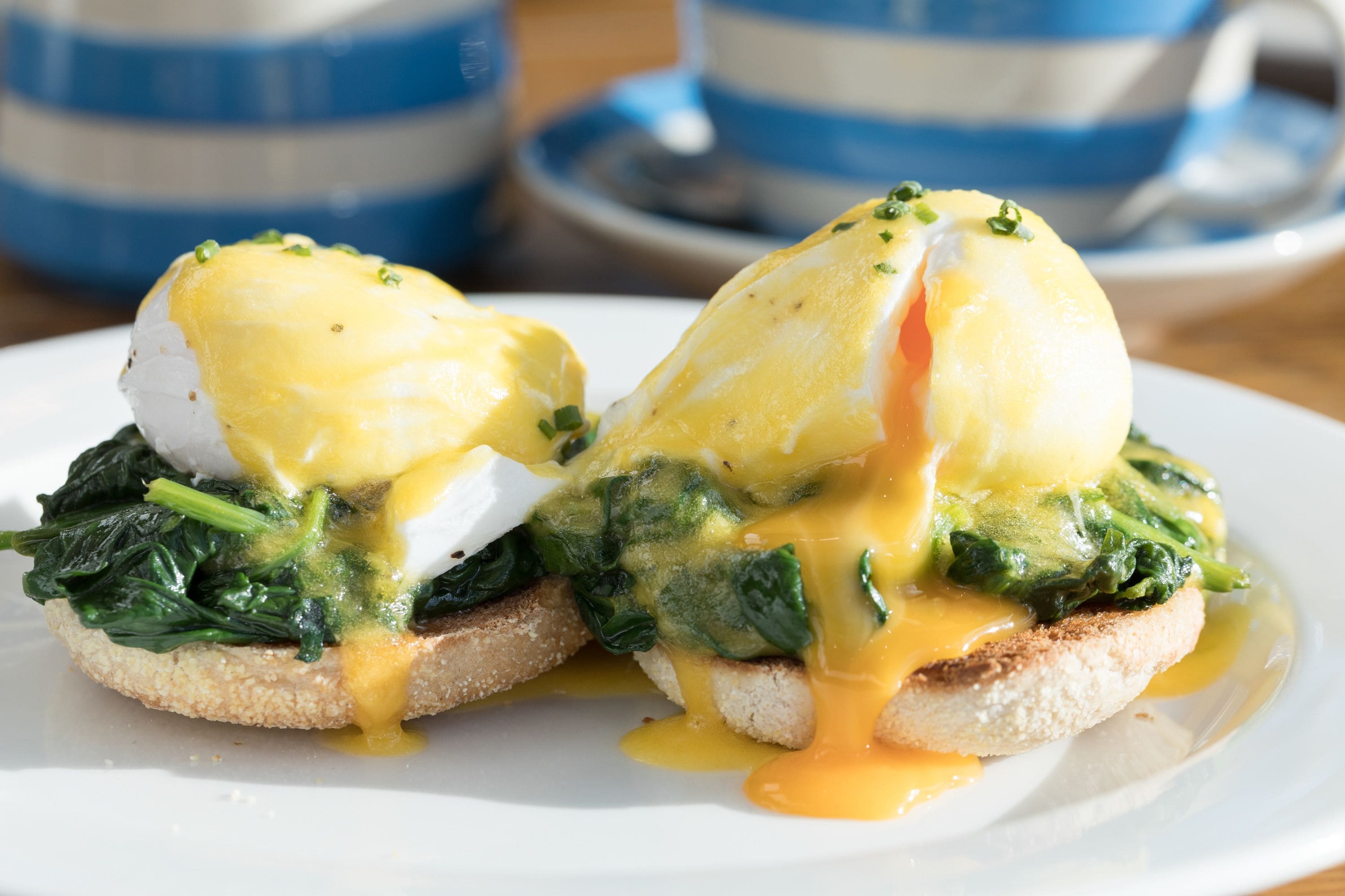 A breakfast dish with eggs, spinach, and sauce on toast.