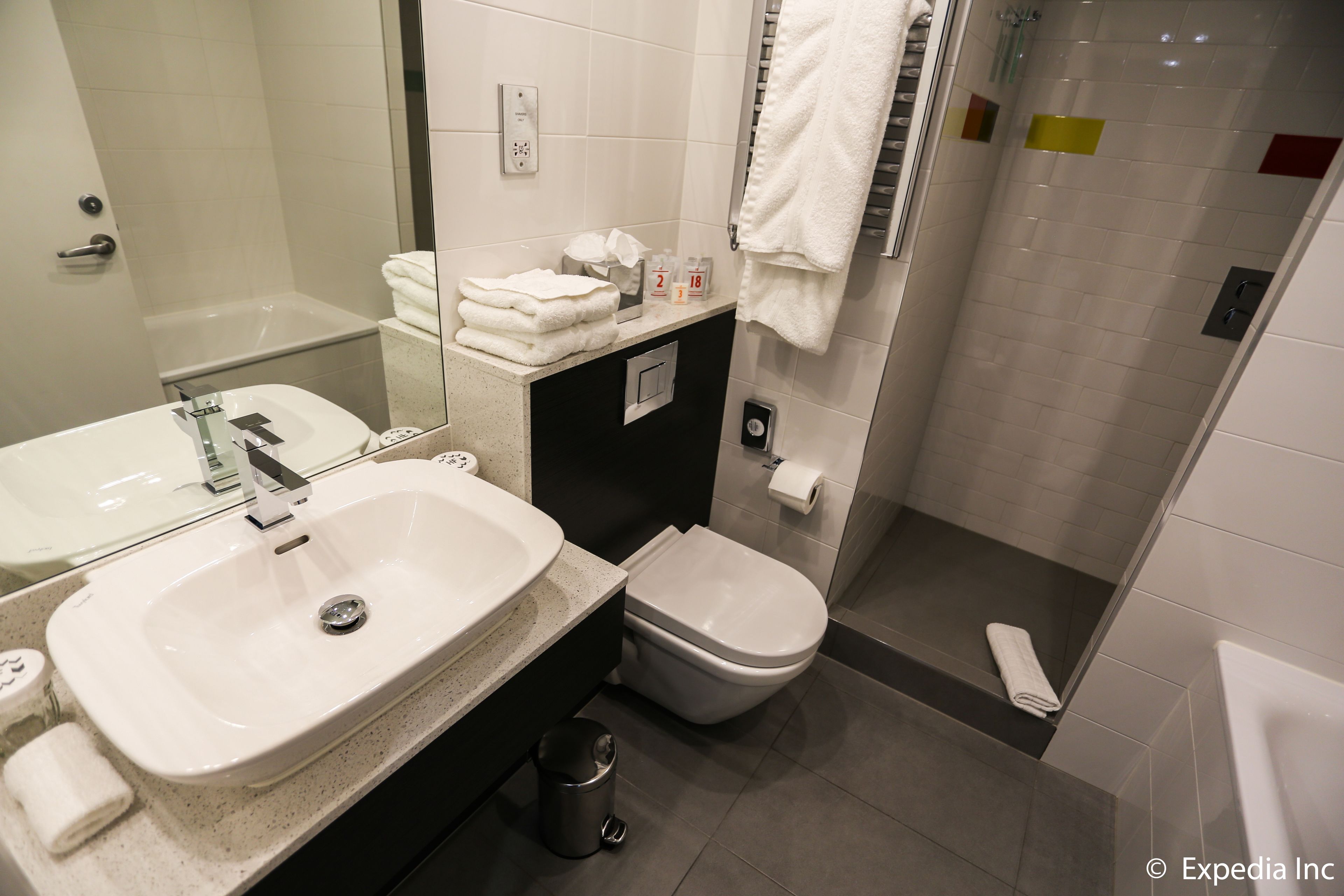 A modern bathroom with a sink, toilet, and shower.