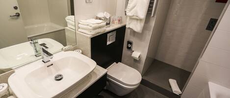 A modern bathroom with a sink, toilet, and shower.