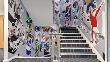 Stunning staircase with a vibrant mural and modern metal handrails.
