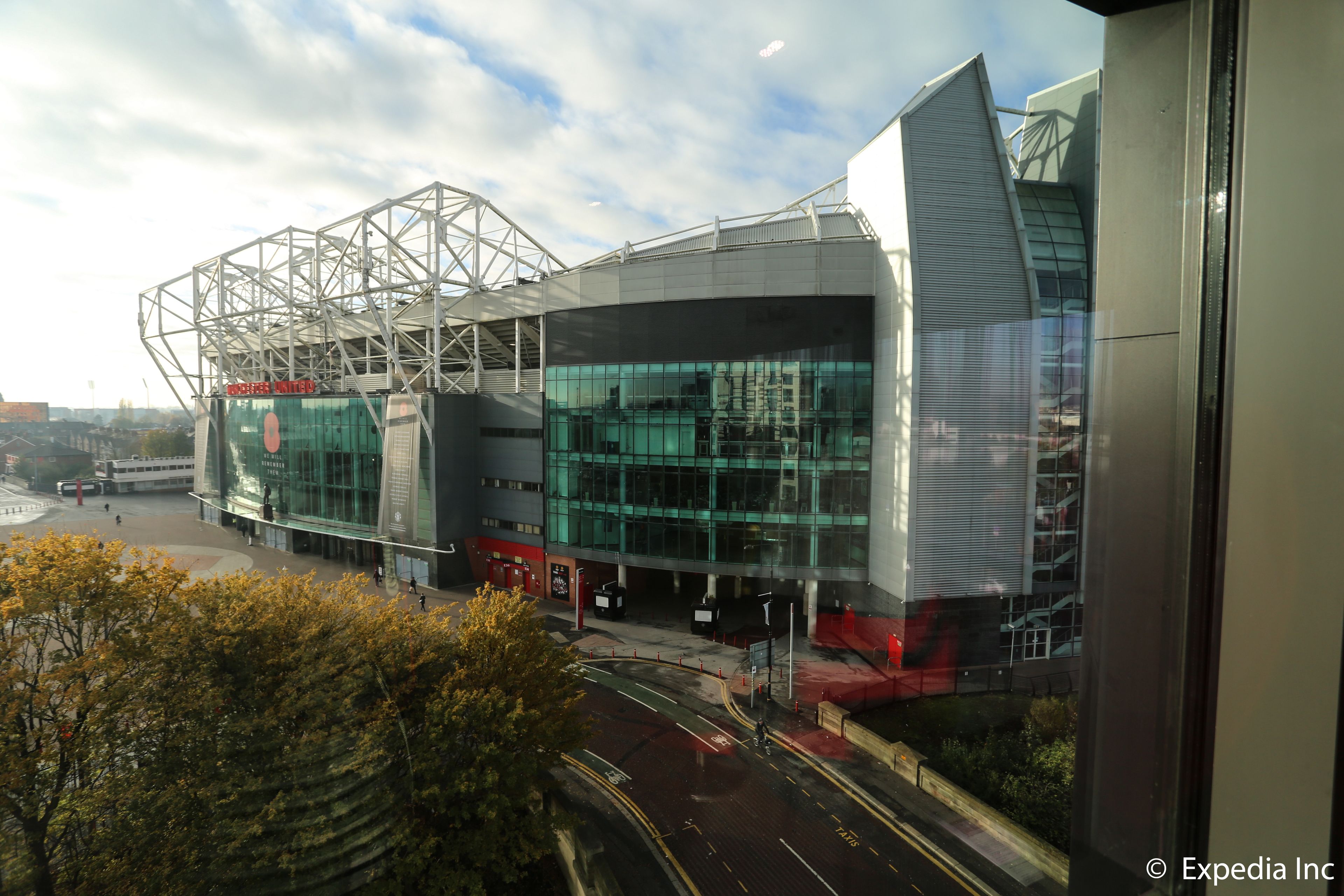 A modern stadium with a glass facade and a distinctive roof structure.