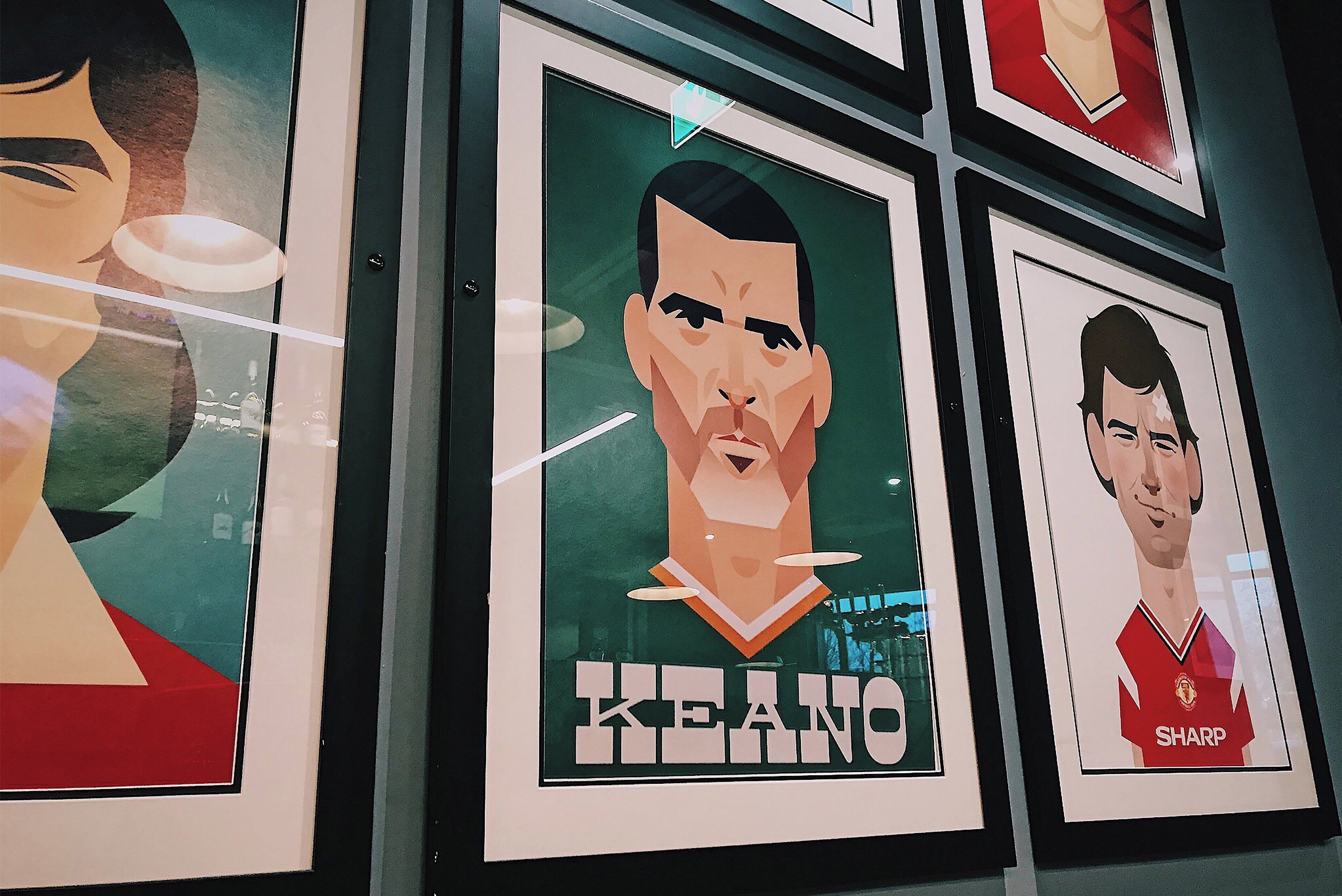 Framed portraits of football players on a wall.