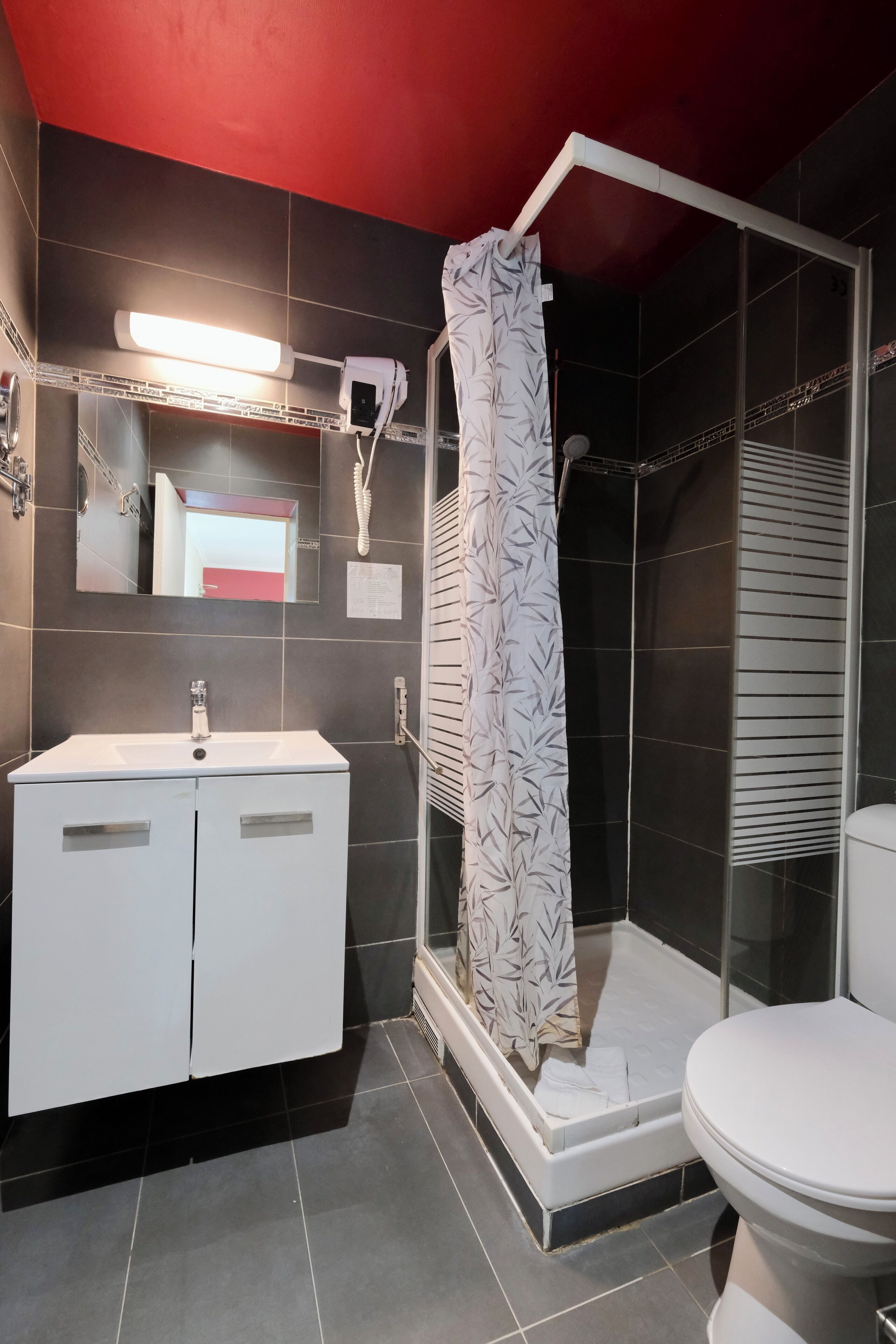 A modern bathroom with a shower, toilet, and vanity.