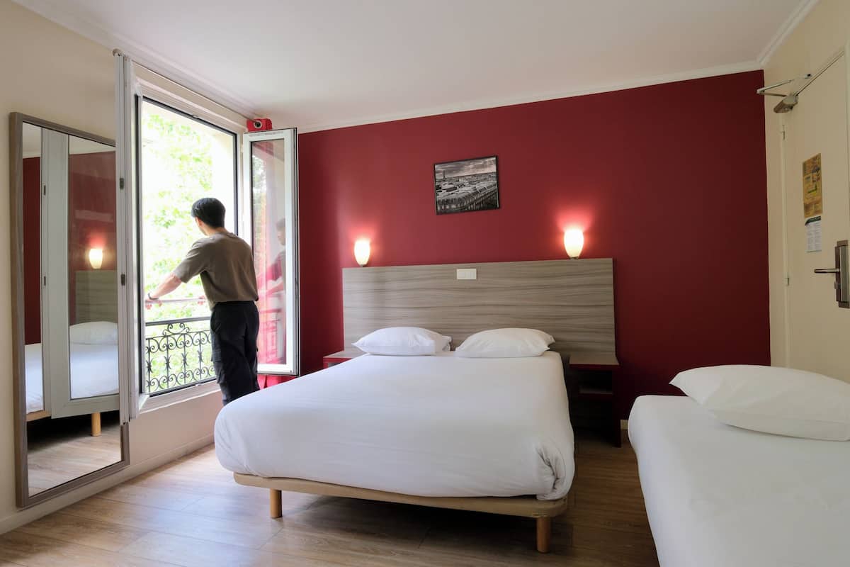 A bedroom with a bed, a window, and a door.