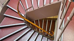 A spiral staircase with wooden handrails and metal balusters. - Hipotel Paris Gambetta Republique (Paris)