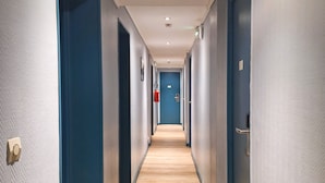 A long, narrow hallway with blue doors on both sides and a wooden floor. - Hipotel Paris Gambetta Republique (Paris)