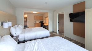 A hotel room with two beds, a television, a desk, and a kitchenette in the background. - Holiday Inn Express & Suites Rochester Hill - Detroit Area by IHG (Rochester)