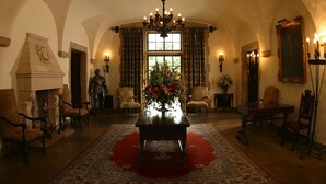 A room with a chandelier, a fireplace, and a large window with curtains. - Graylyn Estate (Winston-Salem)