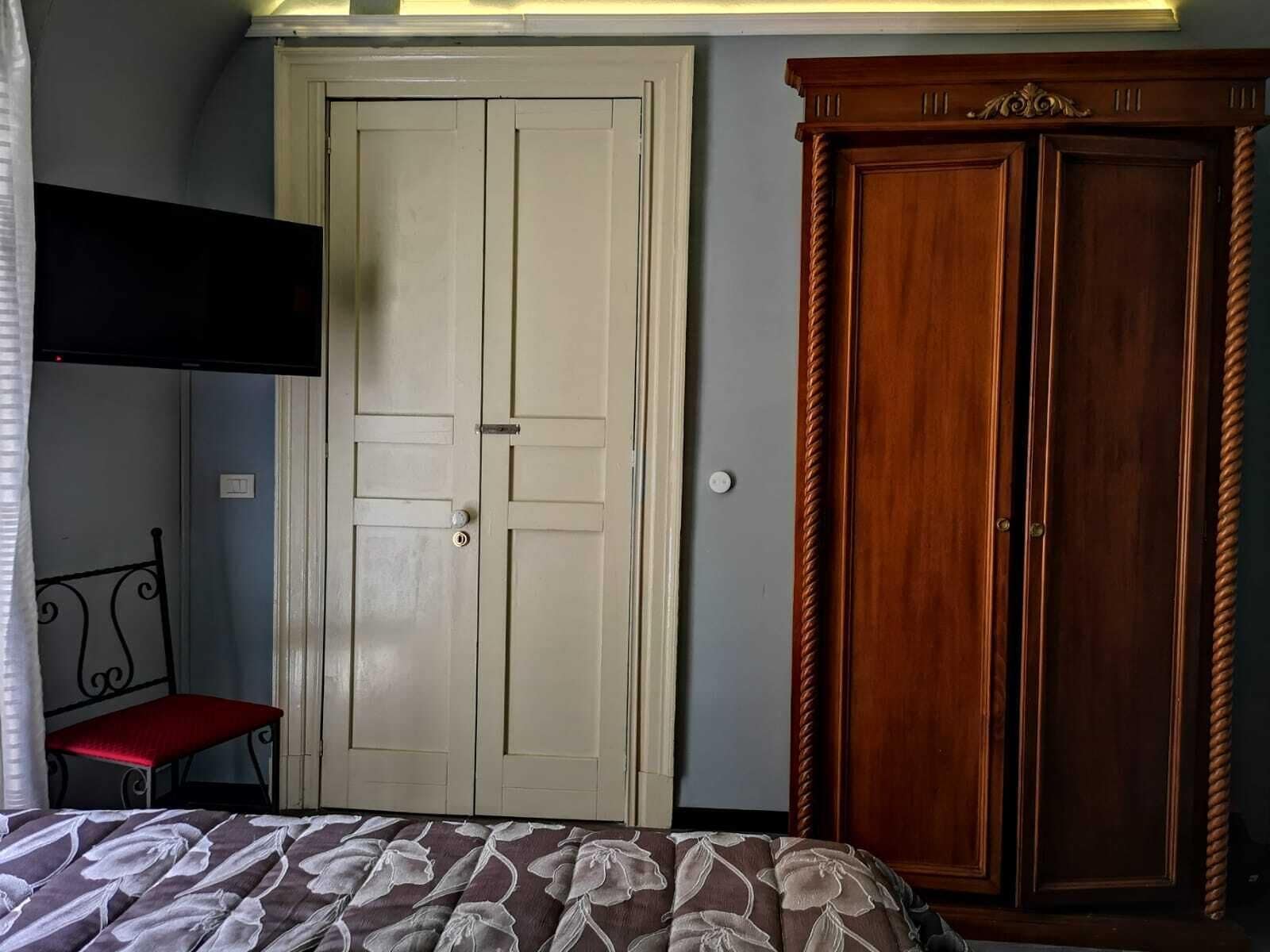 Un dormitorio con cama, armario y puerta.