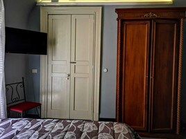 A bedroom with a bed, a wardrobe, and a door.