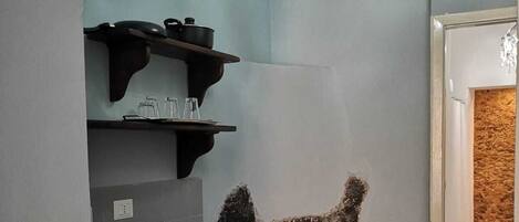 A kitchen with a unique stone wall feature, a built-in sink, and a chandelier.