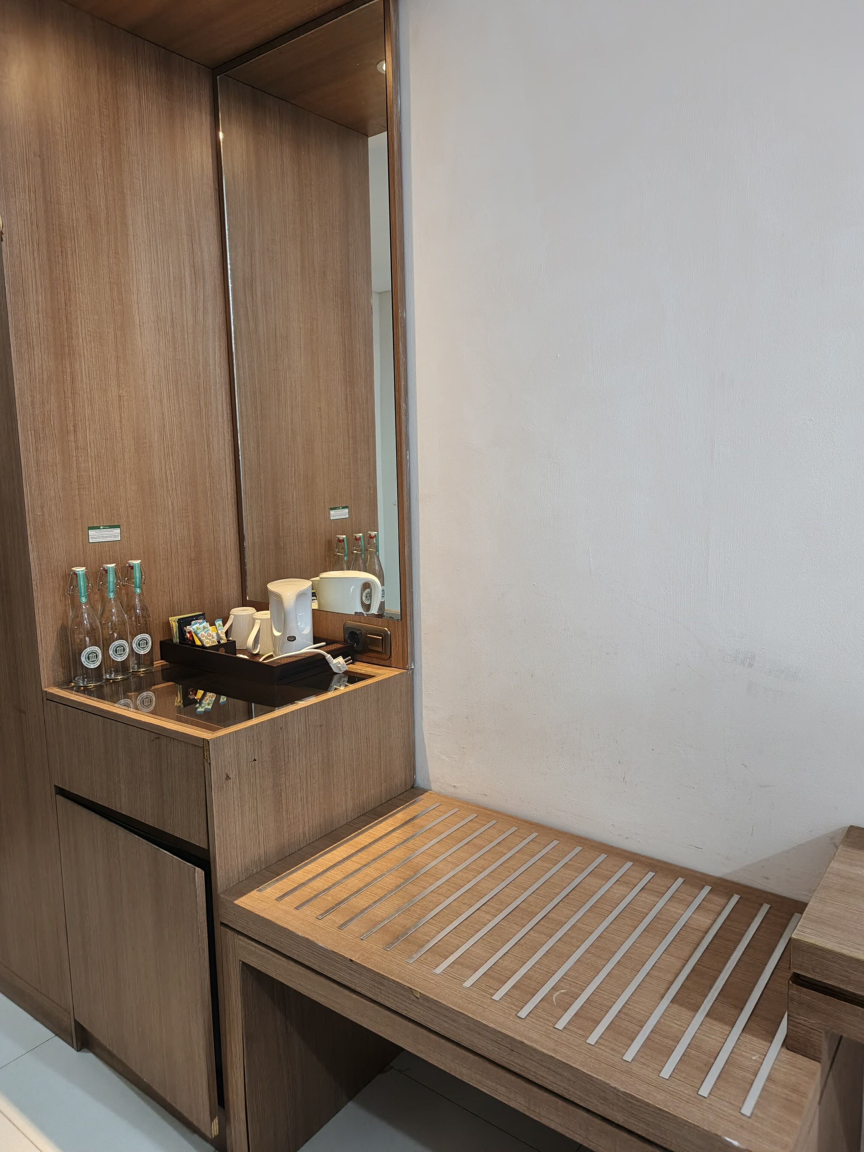 Un baño moderno con tocador de madera, un espejo y un perchero para toallas.