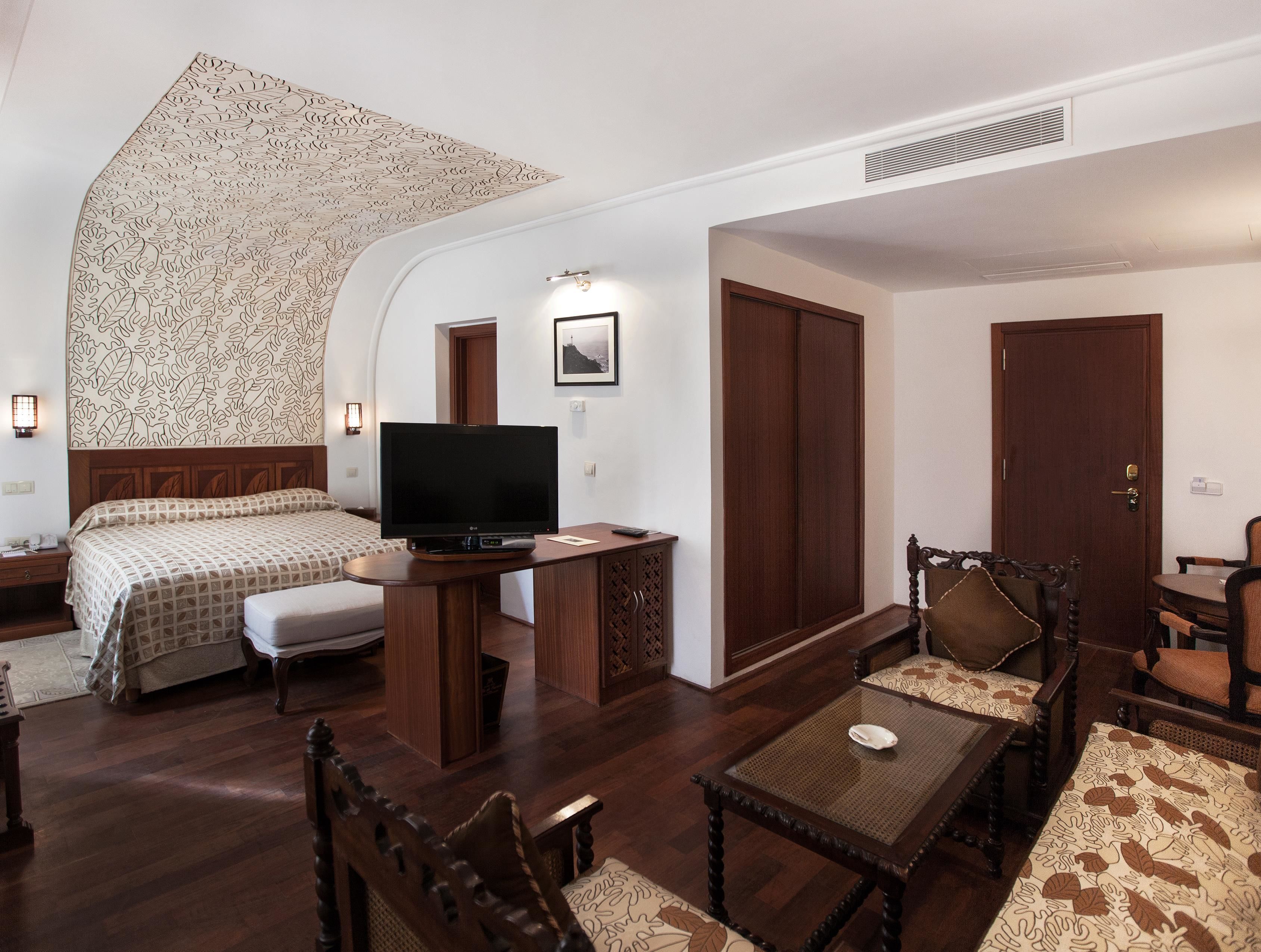 Une chambre d’hôtel équipée d’un lit, d’une télévision, d’un bureau et d’un coin salon.