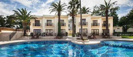 Una piscina al aire libre, sillones reclinables de piscina
