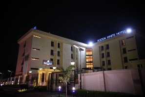 Experience the Bolton White Hotel's elegant facade, featuring a symmetrical design and beautifully manicured garden.