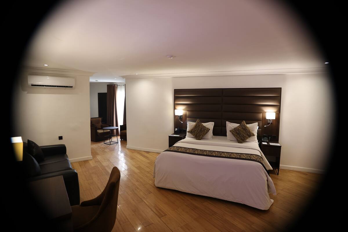 Une chambre d’hôtel moderne avec un grand lit, des lampes de chevet, un bureau et une chaise.