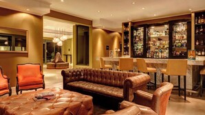 A bar area with leather seating, a bar counter, and shelves of liquor bottles. - Auberge Du Vin, Tupungato, Mendoza (Tupungato)