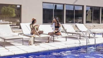 A poolside area with lounge chairs and a swimming pool.